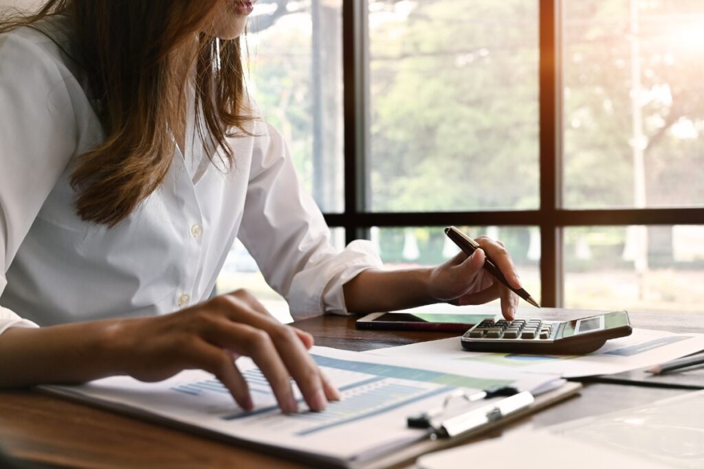 Interim finance professional working on documents with calculator