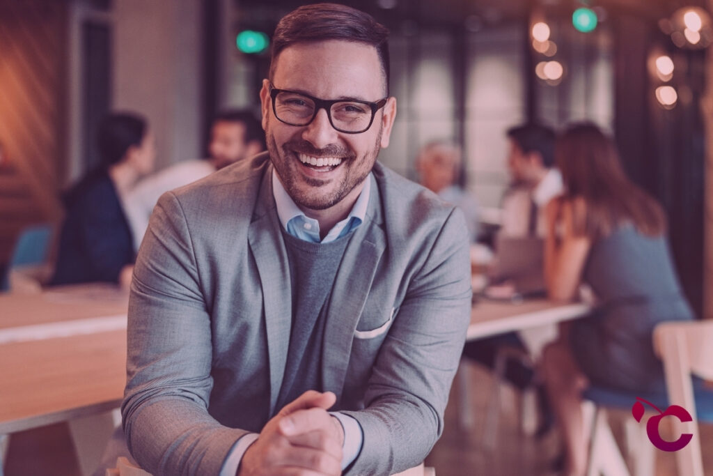 CFO happy with using AI in finance leadership with team talking in the background