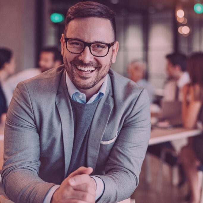 CFO happy with using AI in finance leadership with team talking in the background