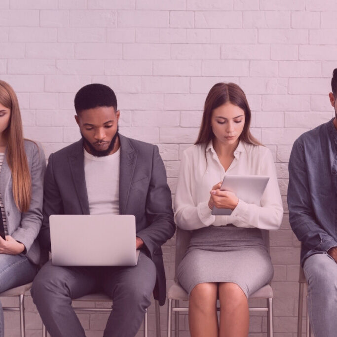 Candidates waiting for job interviews, sitting in row facing recruitment challenge