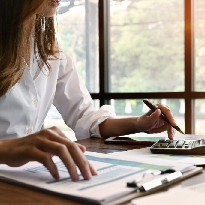 Interim finance professional working on documents with calculator