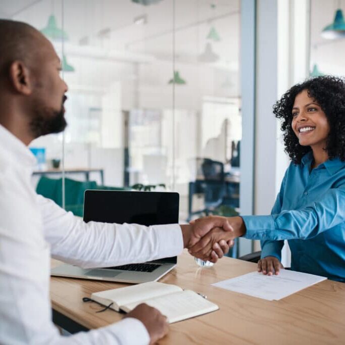 Smiling,African,American,Manager,Sitting,At,His,Desk,In,An